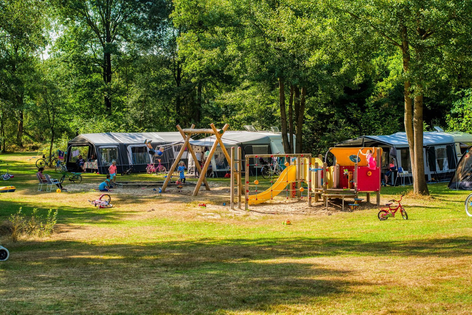 Kamperen op een veldje met uitzicht op een speeltuintje