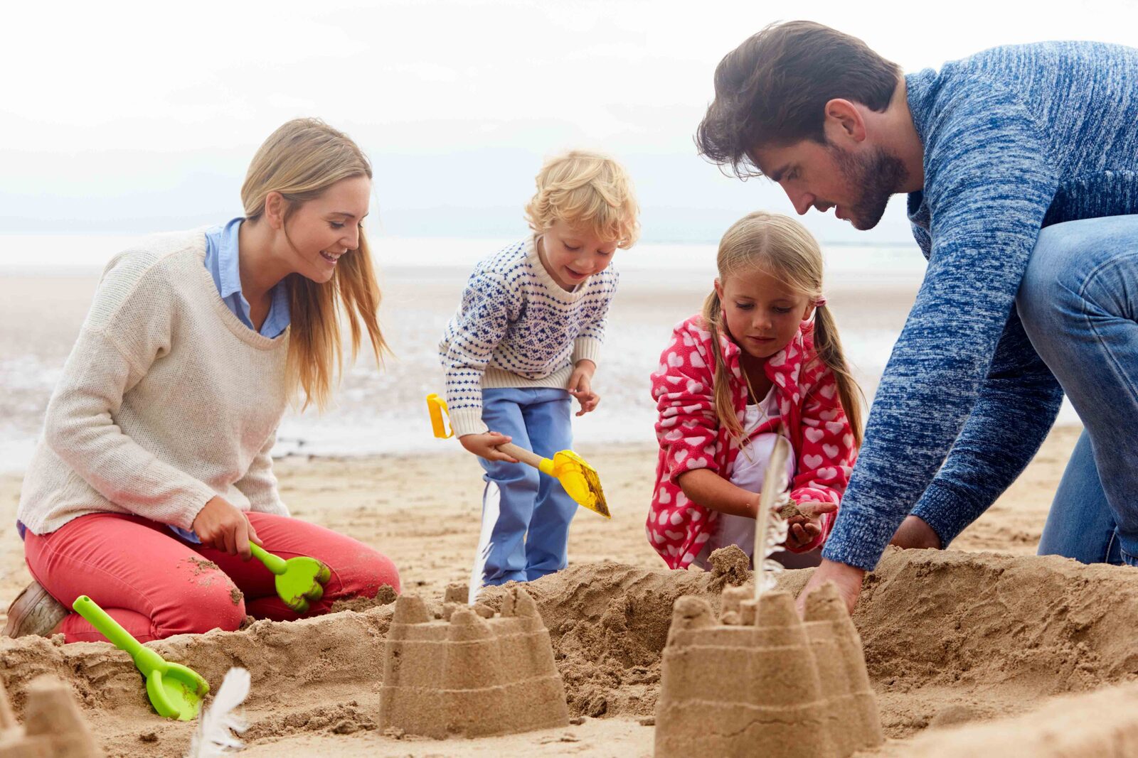 Family on Holidays make Sandcastle